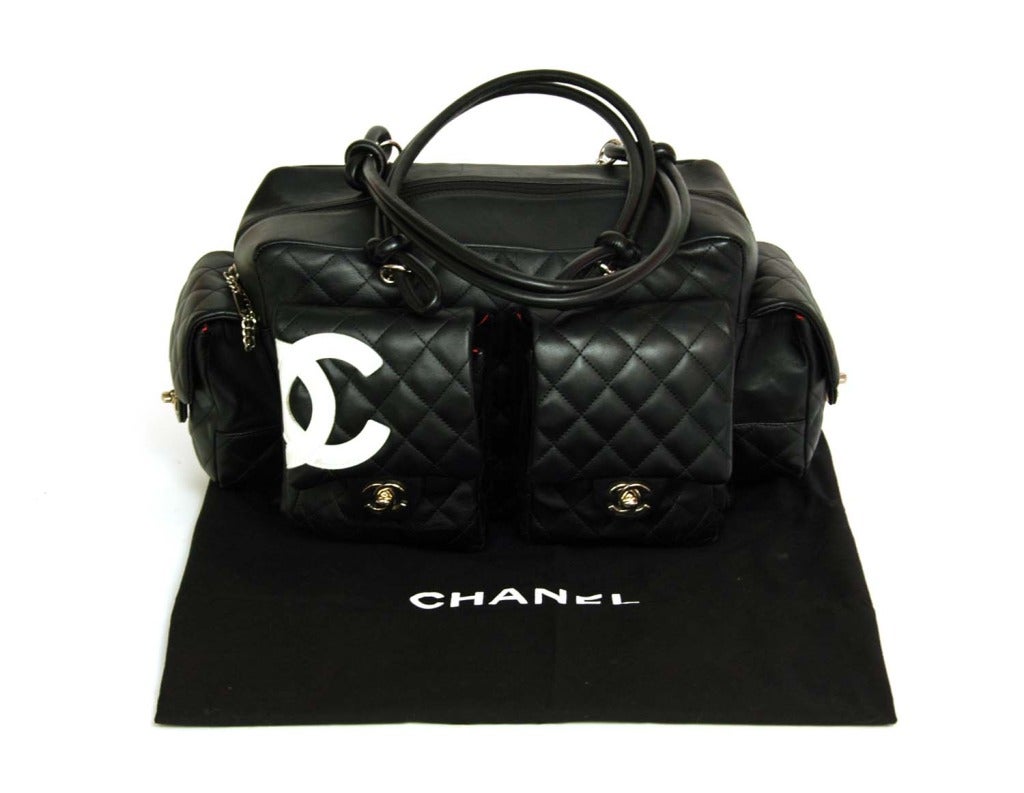 CHANEL Black Quilted Cambon Reporter Bag W. White CC & Quilted Pockets

    Age: c. 2004
    Made In Italy
    Materials: Black lambskin leather, white leather accent, silver hardware, pink logo cloth lining.
    Features four outer pockets