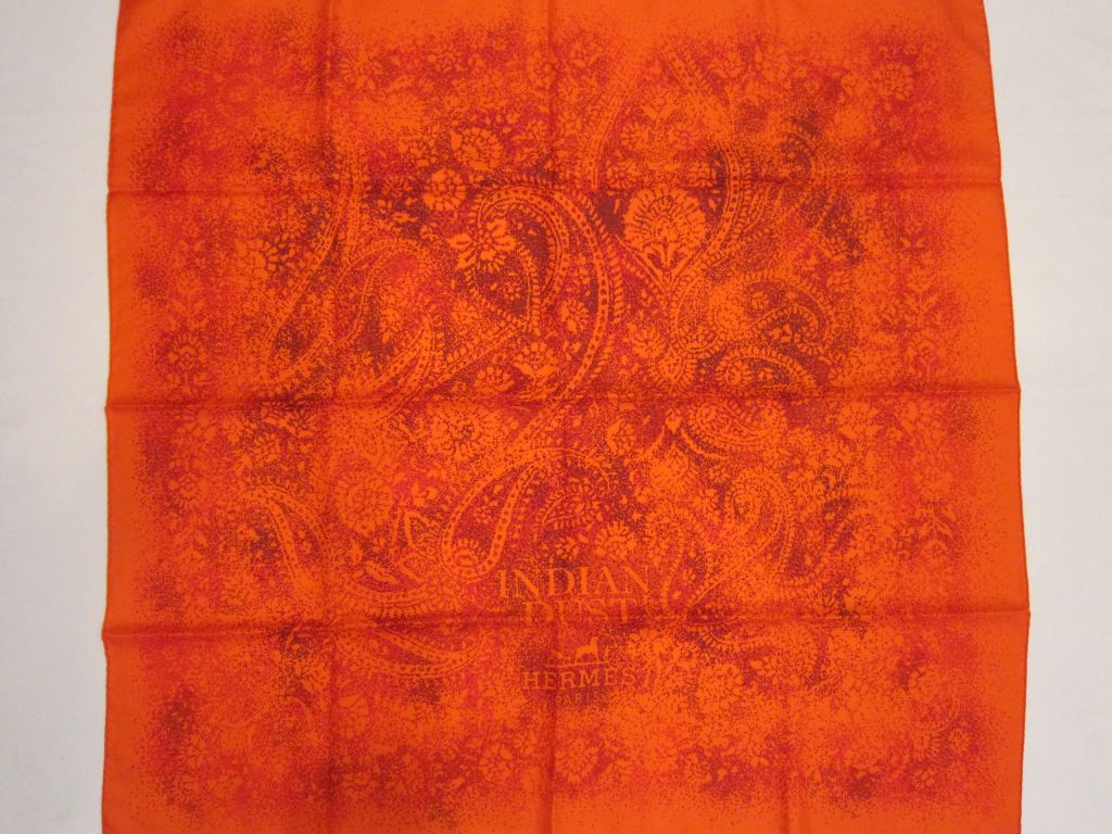 This Orange HERMES  Indian Dust Silk Scarf is a classic addition to any wardrobe.  <br />
<br />
The scarf is made of 100% Silk, hand-rolled.  It can be used as a scarf or shawl.  Join the ranks of royalty and celebs alike, all who have been