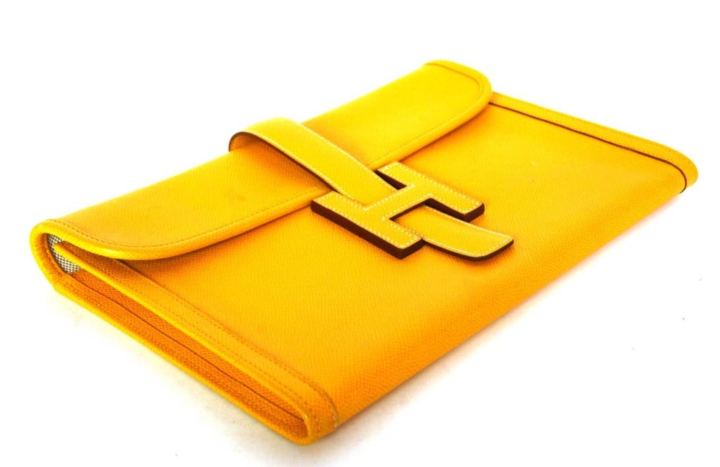 HERMES Yellow Epsom Leather Oversized 'Jige' H Clutch 1997

Age: 1997
Made in France
Materials: yellow epsom leather, beige canvas lining.
Features oversized flap clutch with foldover tab that slides into center white stitched H. Accordion