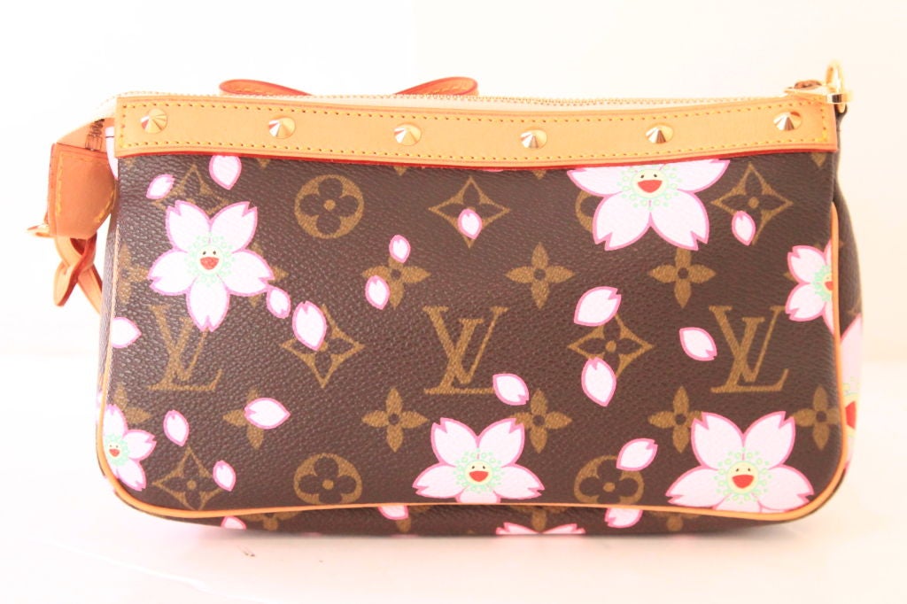 This Louis Vuitton limited edition Murakami Cherry Blossom Pochette is the must-have for all collectors. <br />
<br />
This puchette was created in 2003 by Takashi Murakami for Louis Vuitton.  Feautres monogram canvas with pink cherry blossom