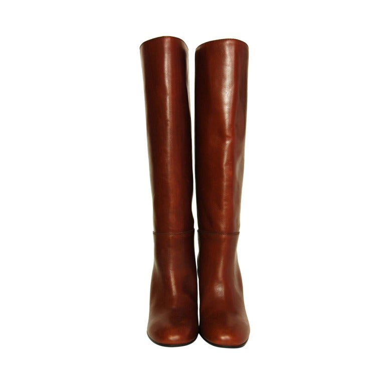 CHANEL Brown Leather Tall Boot W. Stacked Heel Sz. 39.5
Made in Italy
Materials: leather, wooden heel.
Features round toe brown leather boot with stacked heel. Stitched detail, CC charm on outside. 

Marked size: 39.5
Estimated to fit a US