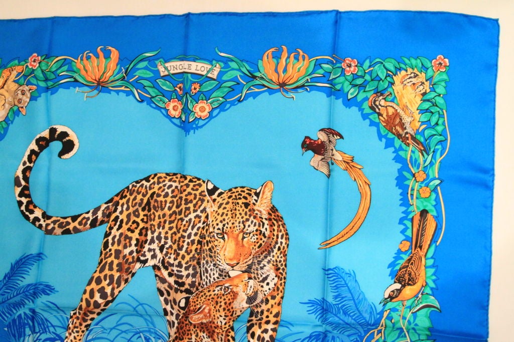 This Blue HERMES Jungle Love Silk Scarf is a classic addition to any wardrobe.<br />
<br />
The scarf is made of 100% Silk, hand-rolled. It can be used as a scarf or shawl. Join the ranks of royalty and celebs alike, all who have been photographed