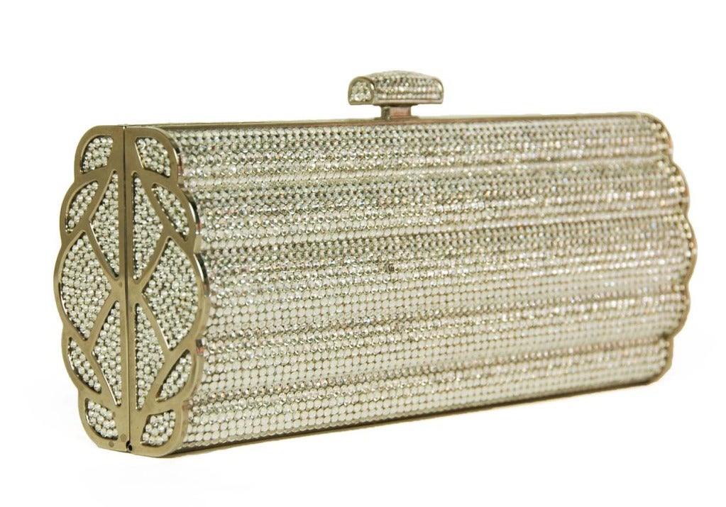 JUDITH LEIBER Silver Swarovski Crystal Minaudiere Clutch RT. $2,995
Materials: swarovski crystals, silver metal, silver leather lining.
Features scalloped capsule clutch in silver rhinestones. Push lock opening. Silver chain can be used as a