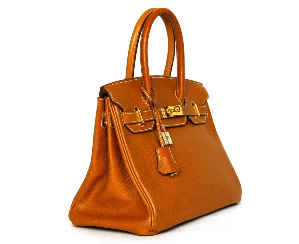 HERMES Tan Togo Leather 30cm Birkin Bag W. Gold Hardware
Age: c. 1988
Made in France
Materials: tan togo leather, goldtone hardware.
Features textured togo leather in classic Birkin shape. Two top handles with dangling clochette (lock and keys).