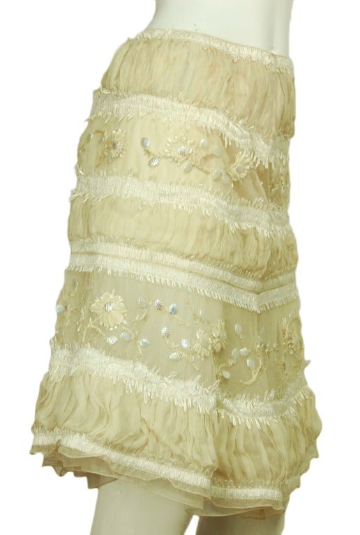 CHANEL Cream Hand Beaded Floral Tiered Skirt Sz. 38 RT. $20,000
Age: 2001
Made in France
Materials: 100% cotton, lining is 100% silk.
Features five tier floral skirt with mesh, raffia, ruffled fabric, yarn and pearlized beads. Flared bottom,