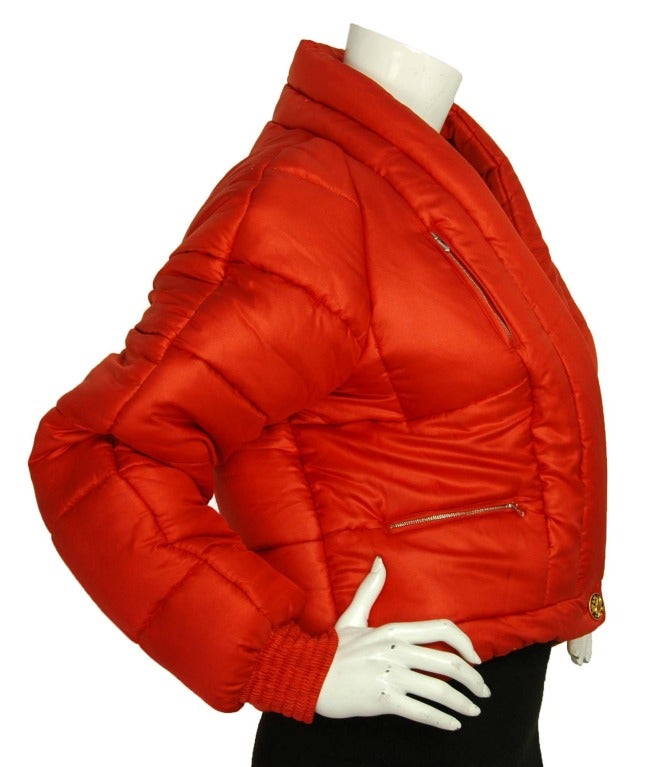 Chanel Red Cropped Puffer Jacket - Sz. Small

Age: c. 2009
Made in France
Composition: 100% Silk
Four front pockets
Front button closure
Black/red/gold CC applique on left sleeve
Labeled 