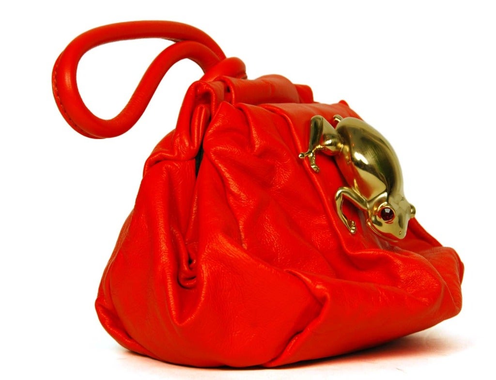 Marc Jacobs Red Leather 'Rana' Clutch W. Goldtone Frog RT. $795
Made in Italy
Materials: red leather, satin lining with suede trim and goldtone hardware and frog with red stone eyes.
Features gathered red leather frame bag with oversized gold