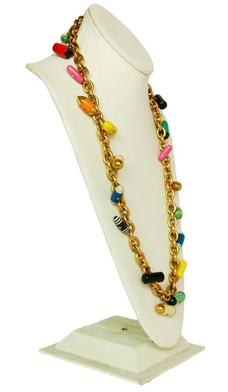 CHANEL Goldtone Chain Necklace W. Multicolor Pill Charms c. 1988
Age: 1988
Made in France
Materials: goldtone metal, assorted plastic pills.
Features strand of gold links with assorted dangling pills. Shuts via hook and eye closure.
Stamped