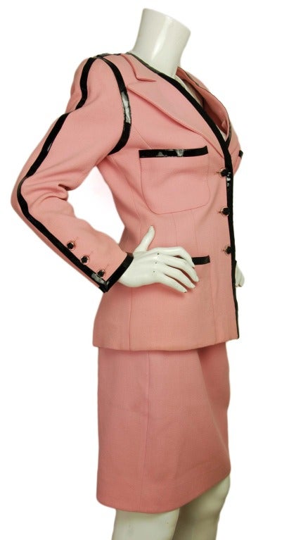 CHANEL Pink Wool Skirt Suit W. Black Patent Leather Piping Sz. 38
Made in France
Materials: 100% wool
Features single breasted pink wool blazer with black patent leather trim and three clear resin buttons with black camellia flowers down the