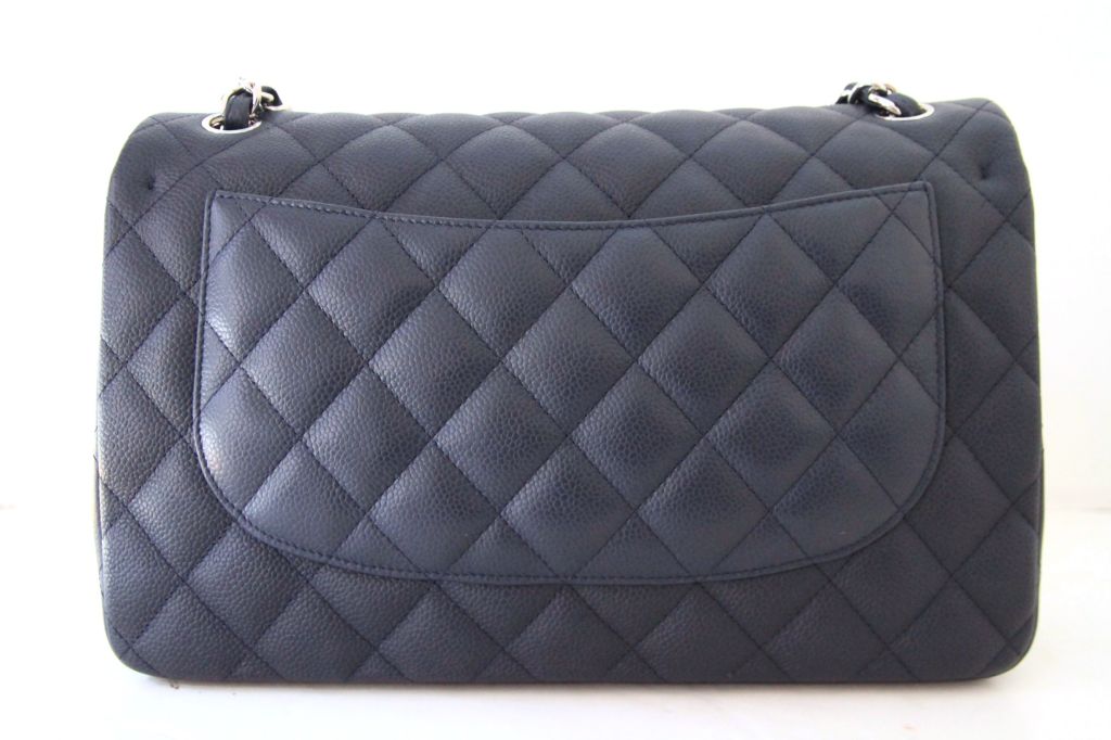 This stunning CHANEL Quilted Navy Caviar Leather Jumbo Double Flap Bag with silvertone hardware is a must-have for every Chanel collector!<br />
<br />
The bag closes with a silvertone CHANEL CC twist-lock closure on the exterior flap and a snap