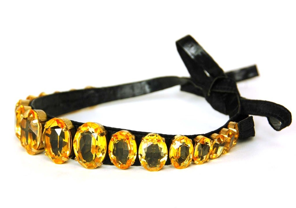 CHANEL Vintage Black Satin Choker Necklace W. Orange Oval Stones c.1987
Age: 1987
Made in France
Materials: satin, leather, orange stones.
Features choker necklace in black satin with leather underside. Oval shaped orange stones throughout. Tie
