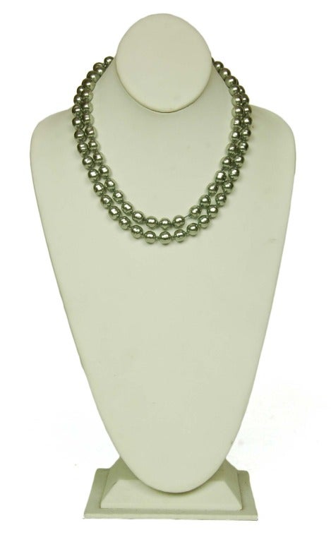CHANEL Vintage Grey Pearl Necklace c. 1981
Age: 1981
Materials: faux pearls.
Features strand of round grey faux pearls. Can be worn long or doubled (as pictured.) Looks great alone or stacked with other necklaces.
Stamped CHANEL 1981

Length:
