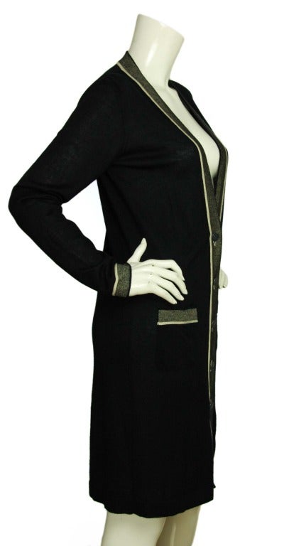 CHANEL Long Sleeve Navy Blue V-Neck Cardigan W. Silver & White Trim Sz. 40 c. 2008
Age: 2008
Made in Italy
Materials: 68% cashmere, 29% silk, 3% other fabrics.
Features long, navy blue v-neck cardigan. Glittery silver trim with white piping. Two