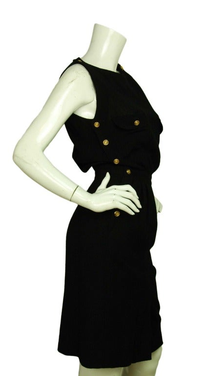 Chanel Black Wool Crepe Sleeveless Dress - Sz 4

Composition tag removed
Twelve goldtone buttons adorn each side with entry on left side
Button and snap closure on top left
Two top pockets with flaps and goldtone buttons
Two side pockets