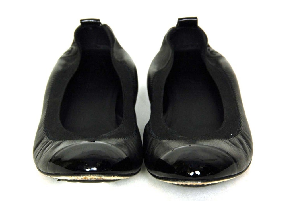 CHANEL Black Leather Elastic Ballet Flats W. Patent Trim Sz. 40
Made in Italy
Materials: black leather, black patent leather, black elastic.
Features round toe ballerina flat in black leather with patent cap toe and heel detail and   elastic band