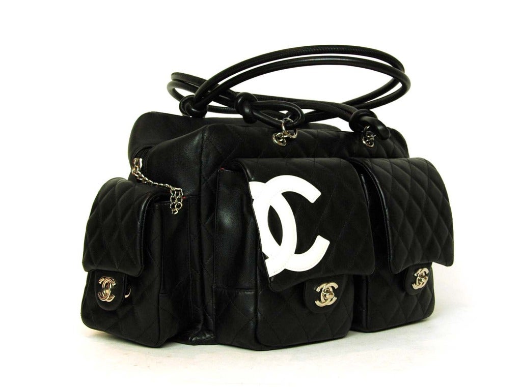 Chanel Black Quilted Leather Cambon Reporter Tote

Age: c. 2004-2005
Made in Italy
Materials: leather, silvertone hardware
Exterior features two front pockets with flap and CC twist lock,two side pockets with flap and CC twist lock and one back