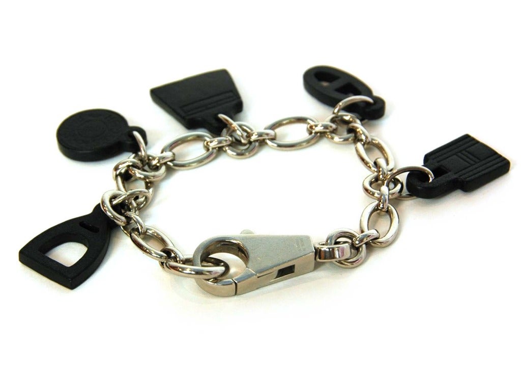 Hermes Black Leather OLGA AMULETTE Bag Charm

Made in France
Materials: silvertone metal, leather
Five leather Hermes charms hanging from a silvertone link bracelet. Can be used as a bag charm or a bracelet.
Lobster claw closure
Stamped