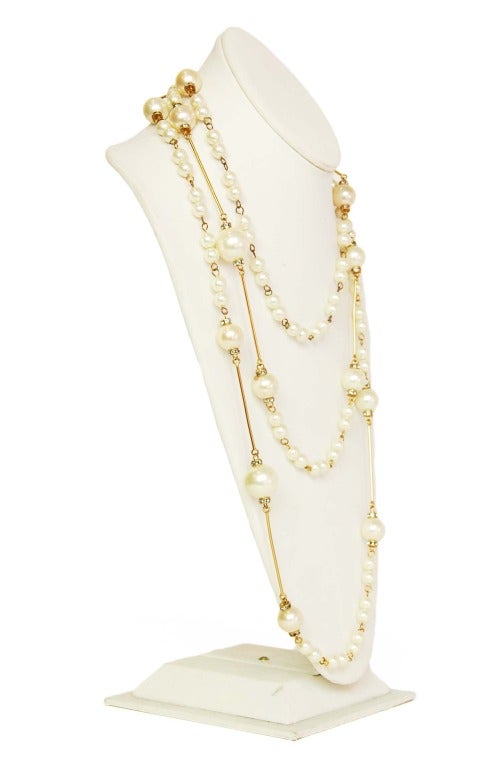 Chanel Pearl Necklace With Gold Rods

    Age: c. 2001
    Made in France
    Materials: goldtone metal, pearls, rhinestones
    Larger pearls feature two small circles of rhinestones and gold bars
    Stamped 
