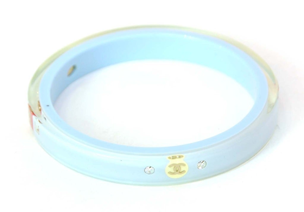 CHANEL Narrow Blue Resin Bangle With Logo CC's & Stones c. 2008

Age: 2008
Made in France
Materials: clear resin with blue center, silver stones.
Features narrow clear resin bangle with blue center. Four logo CC stations with silver stones on