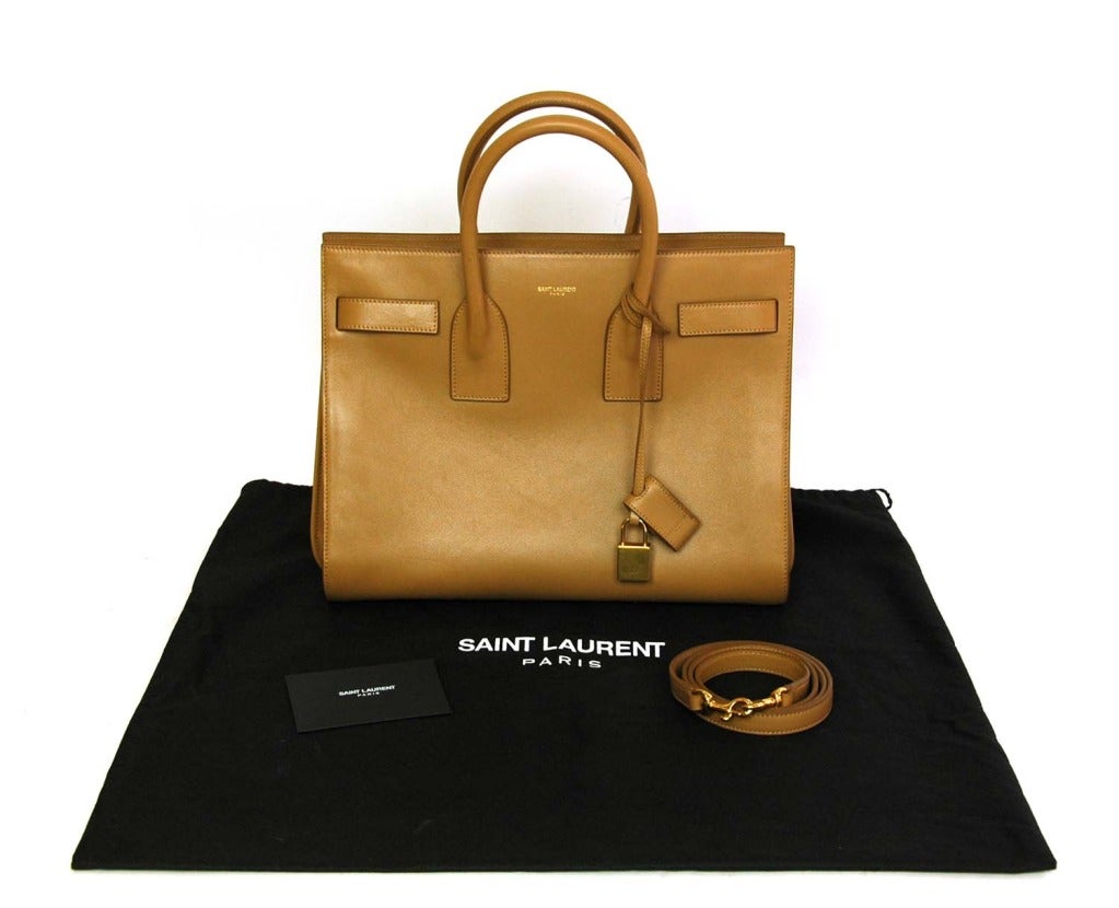 SAINT LAURENT Beige Leather 'Sac De Jour' Tote Bag RT. $2550 c. 2013
Age: 2013
Made in Italy
Materials: beige leather, gold hardware, beige suede and fabric lining.
Features structured tote with accordion sides in beige leather. Two top handles