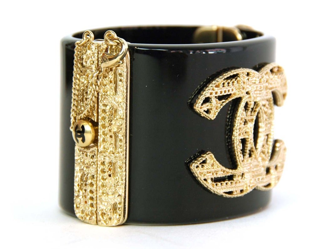 Chanel NEW Black Resin Cuff With Filigree CC

    Age: c. 2013
    Made in Italy
    Materials: resin, filigree
    Slide closure with lobster claw lock on a chain
    Stamped 