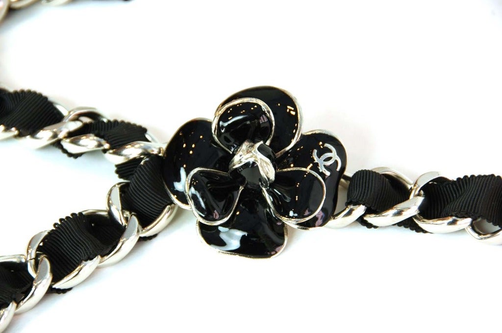 Chanel Chain Belt With Black Woven Grosgrain Ribbon And Enamel Camelia

    Age: c. 2006
    Made in France
    Materials: silvertone metal, grosgrain ribbon, enamel
    Hook closure
    CC logo on camelia
    Stamped 