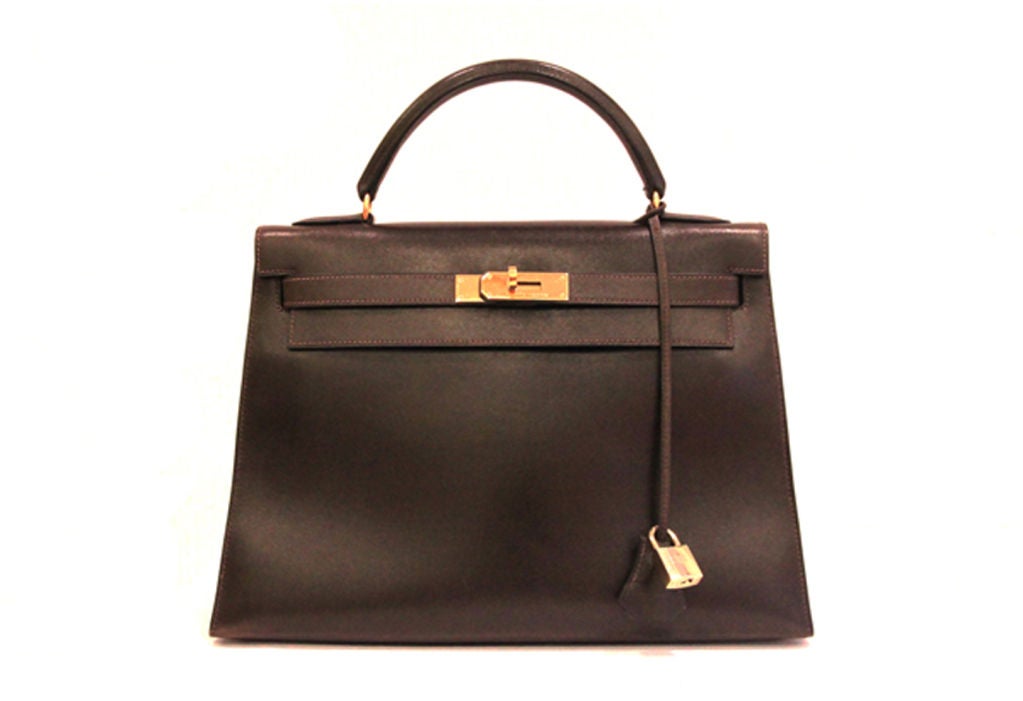 A timeless classic in a gorgeous chocolate brown colorway!<br />
<br />
Made in the most luxurious box leather with golden hardware.<br />
<br />
Top handle with front flap and twist lock closure.<br />
<br />
Hardware on leather strap is