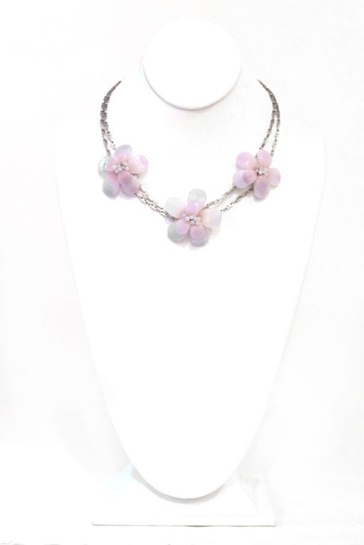 This 98's spring collection beauty is a perfect addition to any Chanel lovers collection. Three resin flowers in shades of lavender and pink on two rose of silver tone chains. Don't miss the opportunity to make this gorgeous necklace your own.