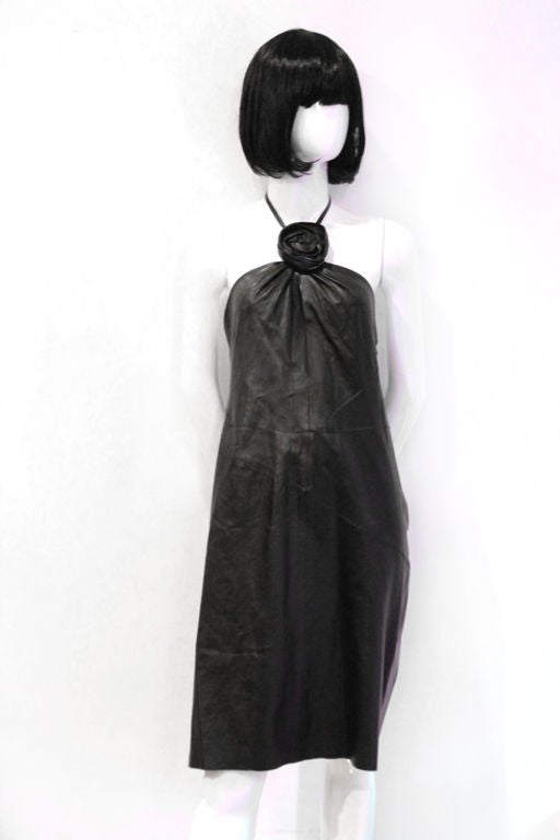 This gorgeous, stunning GUCCI Leather Halter Dress would make a perfect addition to any wardrobe.<br />
<br />
Features black leather body with tonal leather trimmed flower on the front of the dress.  It closes with a side zip closure and a hook