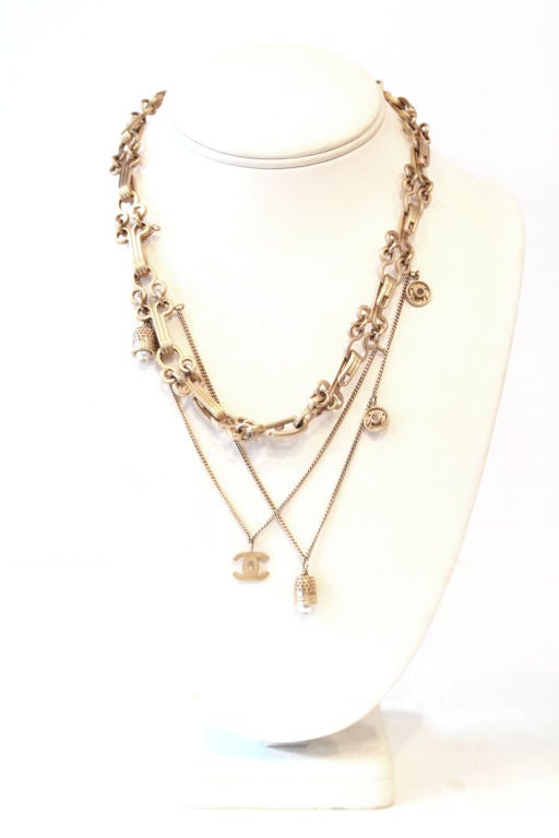 This rare CHANEL necklace is the perfect addition to your CHANEL collection. Features brushed golden metal linked hook-and-eye with chains and CC logo and bell with pearl charms. Hook closure on the back.<br />
<br />
Stamped with CHANEL 03 CC A,