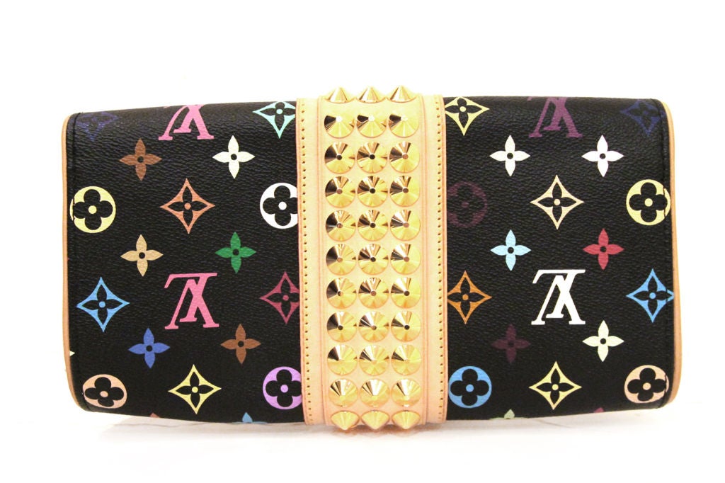 This LOUIS VUITTON Courtney Clutch is made of black monogram multicolore canvas and natural cowhide leather trim with golden hardware.  Features golden studded details wrapped around the center of the clutch.  It closes with a golden push lock