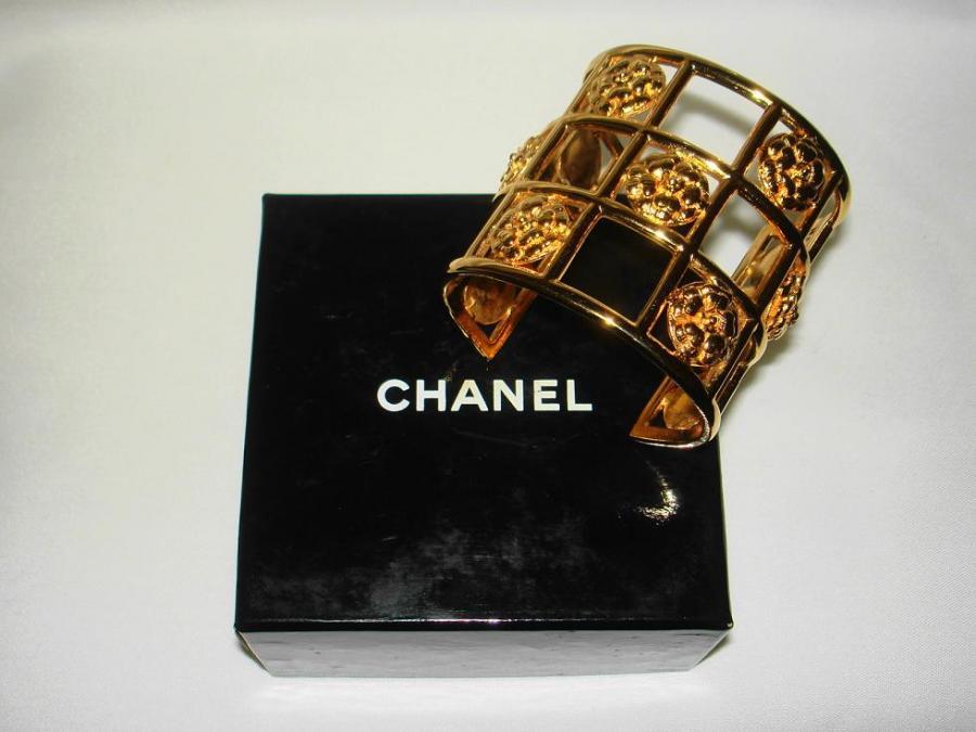 This CHANEL Golden Cage Cuff Bracelet has multi CHANEL Camellias. 1.5