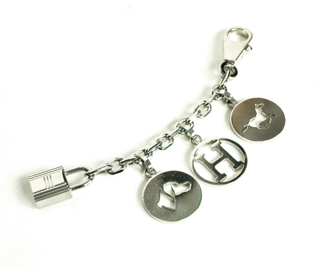 Hermes Silver Bag Charm
Features H, Dog & Horse Cut Out Shapes
Lock On One End & Closure On Another

Measurements: 

Total Length: 5.5