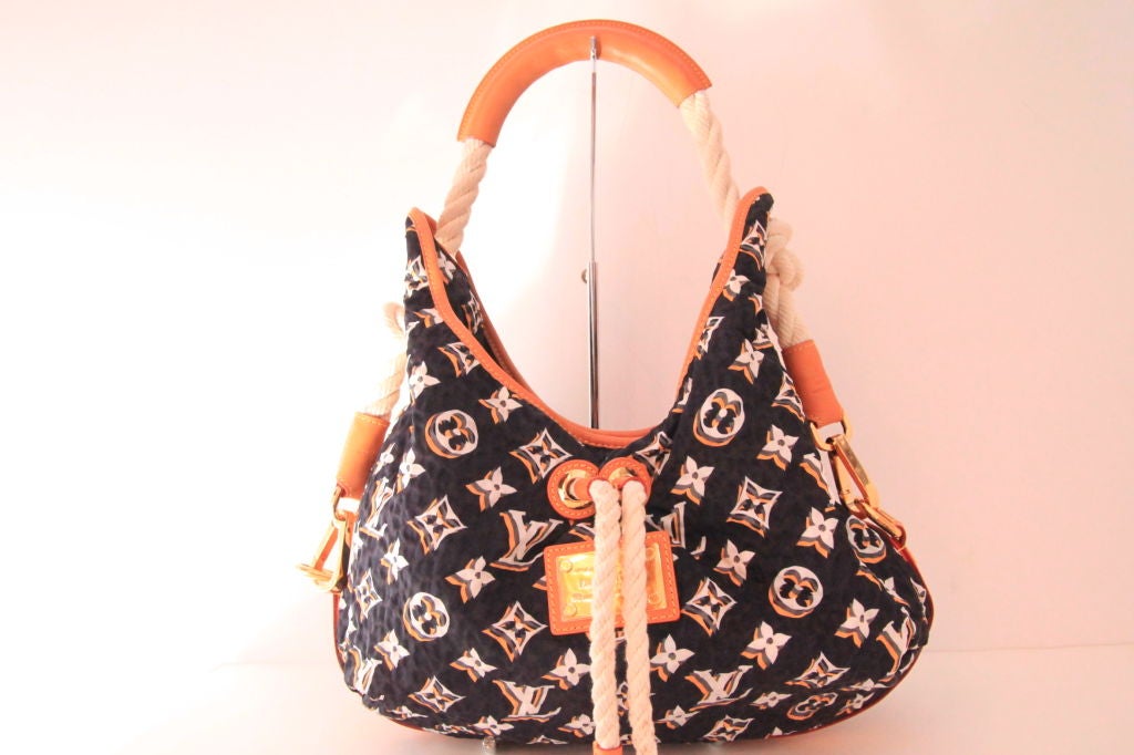 This rare LOUIS VUITTON Monogram Cruise Bulles MM Hobo is a must-have for Spring/Summer!  From the Louis Vuitton 2009 collection.  This spacious bag combines canvas and calf leather with rope accents and gold tone hardware.  The canvas navy body