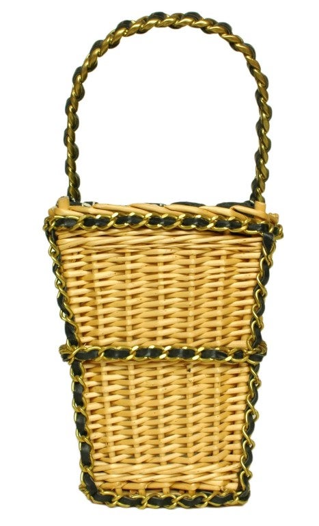Chanel Vintage Picnic Basket With Top Handle (Circa 1990's)
Age: 1991-1994
Made In France
Materials: Wicker, Fabric Lining
Exterior Trimmed With Leather/Brushed Goldtone Chain
Fabric Tie Closure
Hologram Sticker Reads:  