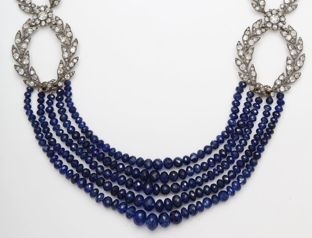 A sapphire and diamond necklace designed as multiple graduated rows of sapphire bead briolettes, adjoined with antique old European and rose-cut diamond oval-shaped links of foliate motif; diamond elements with French assay and maker's
marks;