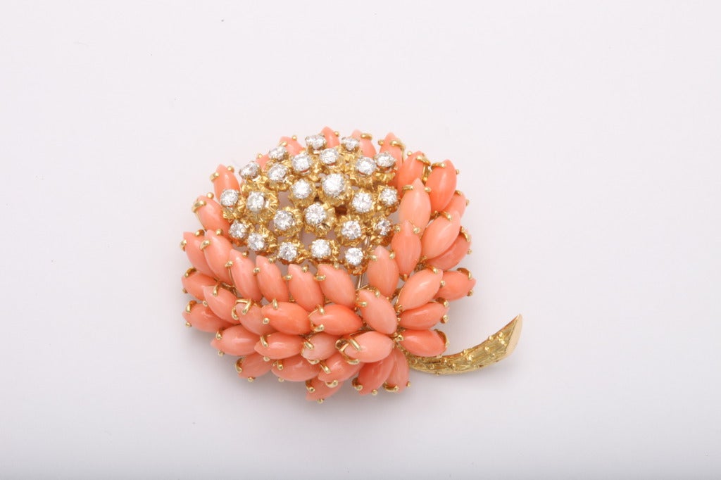 A whimsical Coral and Diamond flower brooch by Van Cleef & Arpels. Consisting of marquise shaped coral and round diamond weighing approximately 1.75 carats, G color VVs2 quality. Set on 18KT yellow gold. Signed with French Hallmarks.