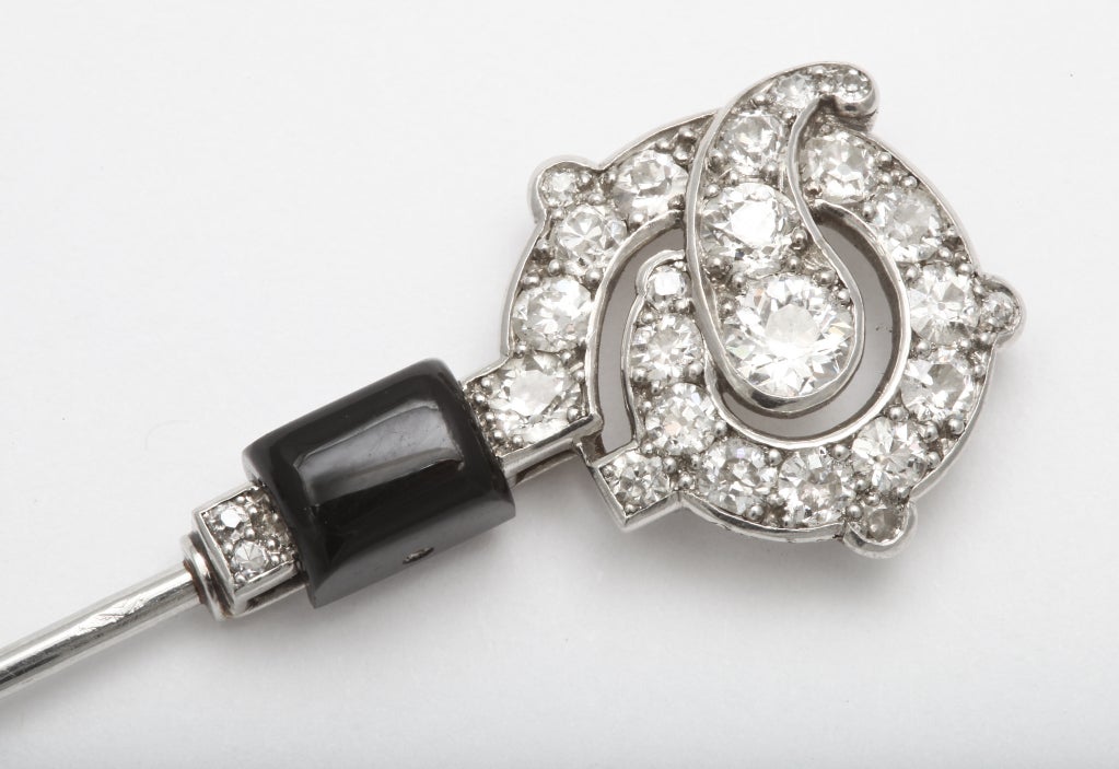 A rare art deco jabot pin with old mine diamonds and onyx panels, set on platinum. By Cartier. Signed and numbered with French Hallmarks.