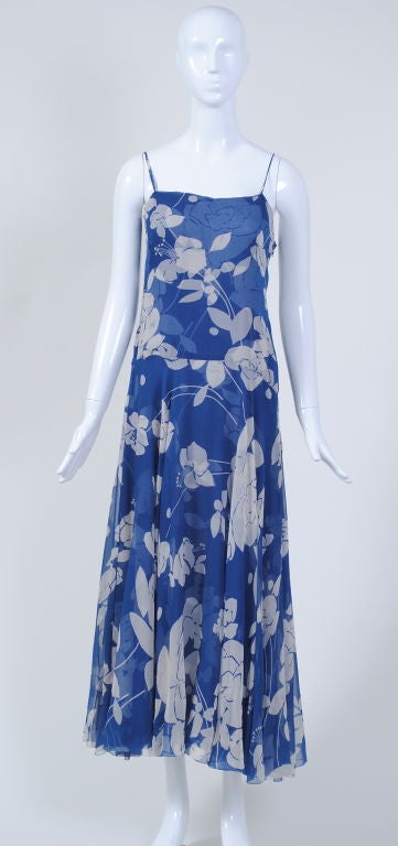 This romantic, blue and white floral print chiffon dress by James Galanos consists of a dropwaist slip dress and a ruffled pullover. The dress has a side zipper, while the jacket, which pulls over the head, features a collar ruffle that is deeper in