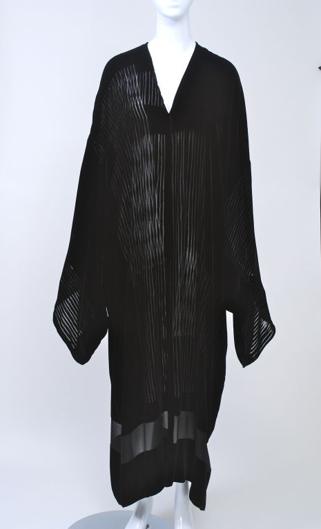 Donna Karan's use of geometric sections of solid, sheer and voided, striped velvet in this evening kimono is fittingly japanesque, from the asymmetric handling of the fabric to the simplicity of the design.<br />
<br />
An elegant float of fabric