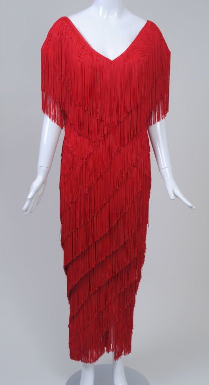 This red fringed gown exhibits Wayne Clark's flair for the dramatic. A fixture on the Canadian fashion scene since the 1970s, Clark is known especially for his Hollywood-inspired evening clothes. Until 1989, when he opened his eponymous label, he