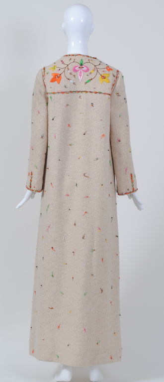 Multicolored embroidery and wooden beads enliven this off-white 1970s maxi-coat by New York designer Gloria Sachs. This ethnic-inspired coat is rather unusual for Sachs, who was trained in textile design and is known especially for her contemporary