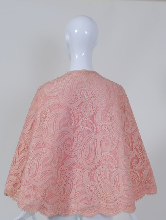 Of scalloped pink lace in a paisley design backed by pink taffeta, this accent piece by Pauline Trigère can accessorize multiple outfits, from a long, flowy dress to white jeans and a tank top for a summer night out. The capelet is nicely