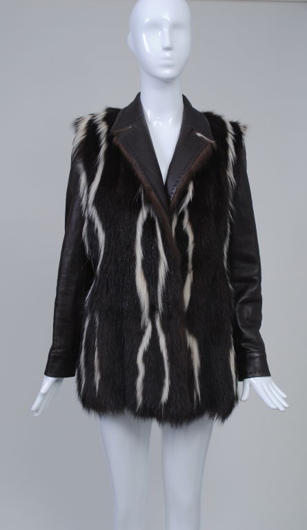 This stunning jacket by Gianfranco Ferre is made of the softest leather, the front enhanced by a coordinating fur in brown with a thin white strip. Styled like a blazer, the jacket is further detailed with a brown running stitch around the lapels,