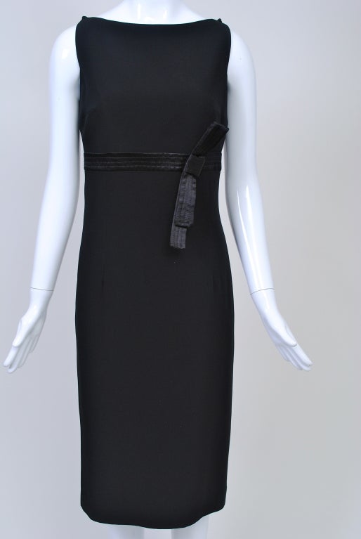 Great LBD by Gianfranco Ferre. Of black crepe, the fitted sleeveless sheath features an empire stitched satin band with bow, squared armholes and overlapping points at the shoulders. In back, the bottom of the skirt flares at the hem to relieve the