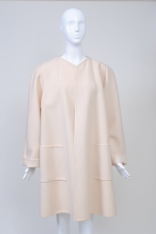 Pauline Trigère was at her best designing coats. Here is a version from the 1980s that, though simple in conception, features the construction and detailing for which she is known. <br />
The short, swing coat is fashioned from a double layer of