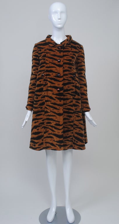 Fabulous Valentino 1960s A-line coat in tiger print velvet features a standaway roll collar, slash pockets with button tab, and deep inverted back pleat. Cut high in the armhole with narrow sleeves, button tab at wrist. Lined in black wool/silk