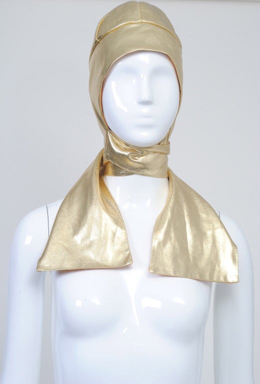Fabulous 1960s Adolfo aviator-style hat in gold lame. Soft fabric hugs the head and long ties wrap or tie as desired. Lined in taffeta.
