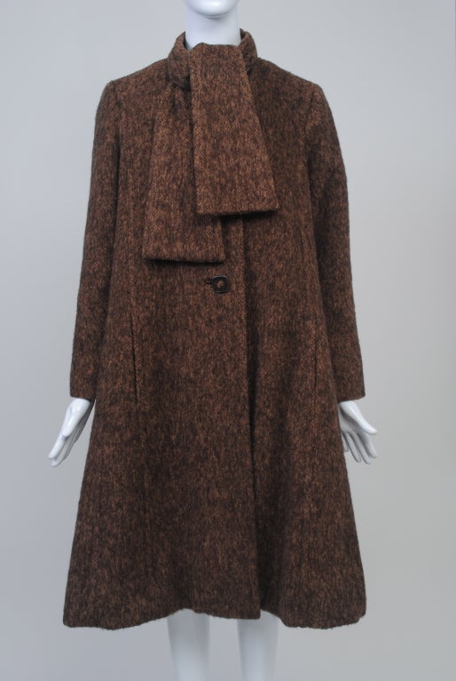 Pauline Trigère designed some of the best coats in America, especially during the 1960s and '70s. This example,in brown tweed  mohair, has a slight swing style, narrow in the shoulders and flaring to the hem by means of  vertical welted sections