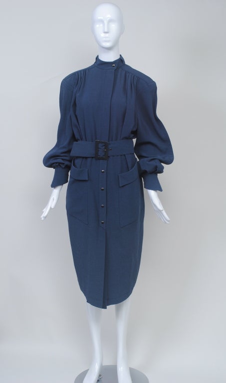 Typical Mugler styling takes the shirtdress to a new level with remarkable detailing. Fashioned out of steel blue gabardine, the dress has a bodice and skirt gathered into a waistband encircled by a wide belt in the same fabric. Snaps down the